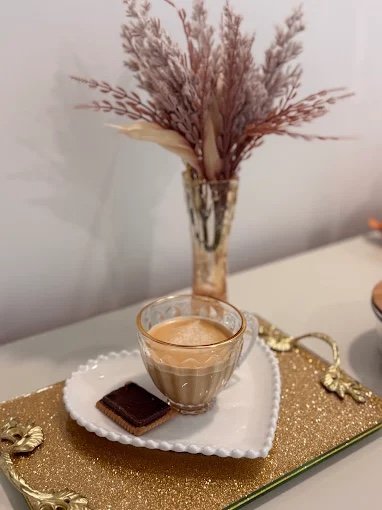 Café servido em xícara de vidro com bandeja dourada